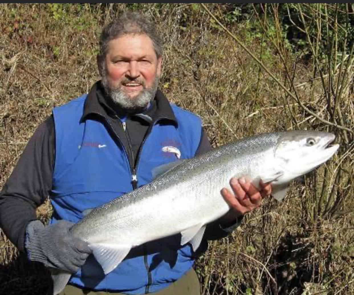 Angler holding a large Rogue River steelhead