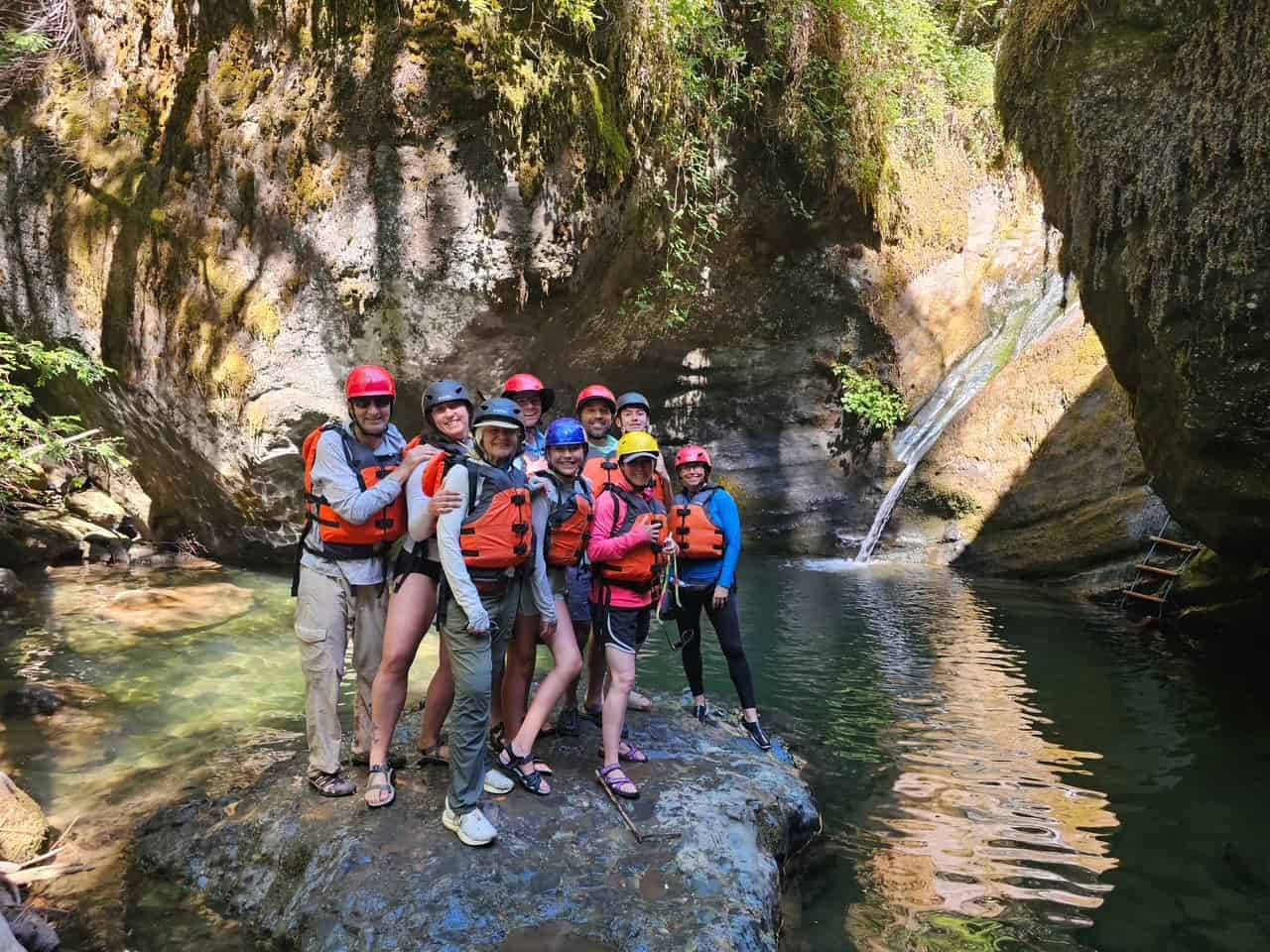 Rafting guests posing at a hidden waterfall grotto on the Wild and Scenic Rogue River
